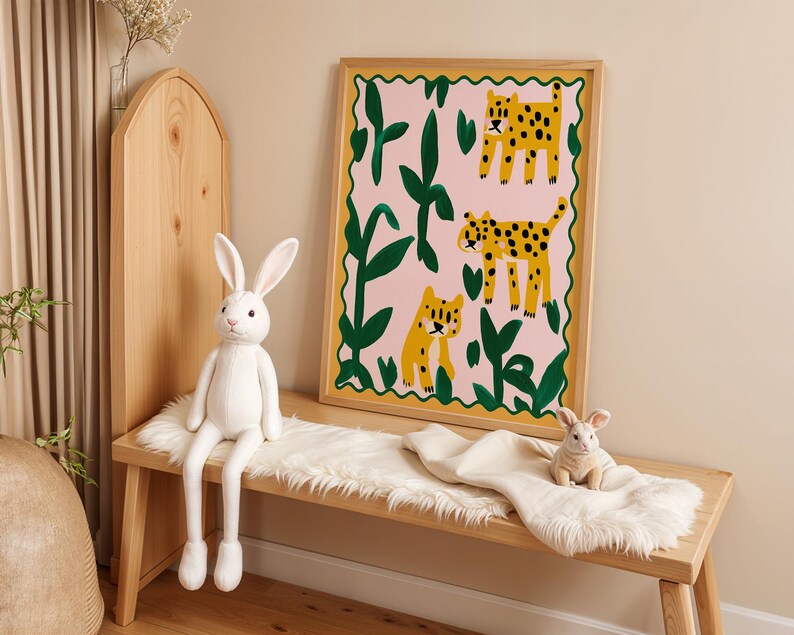 May include: A framed illustration of three leopards in a jungle setting. The leopards are yellow with black spots and are surrounded by green leaves and pink flowers. The frame is made of wood and has a gold finish.