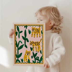 May include: A framed print with a pink background featuring three yellow and green leopards in a jungle setting.