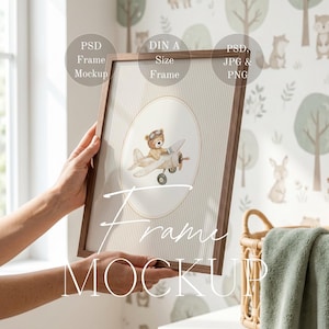 May include: A framed print mockup featuring a watercolor illustration of a teddy bear piloting an airplane. The frame is brown, and the print has a striped background. Text on the frame reads "Frame Mockup".