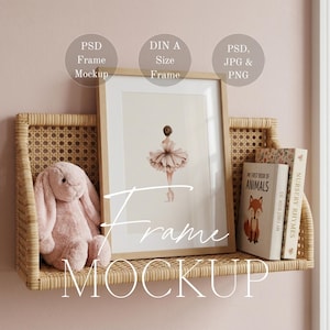 Op de afbeelding: Een ingelijste prent van een ballerina in een roze tutu, tentoongesteld op een geweven plank met een pluchen konijn en boeken. De lijst is van licht hout. Tekst op de afbeelding zegt "Frame Mockup".