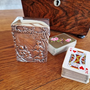 Viktorianische Spielkartenbox aus Sterlingsilber mit detailreicher geprägter Szene, 1898, London, William Comyns & Sons.