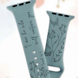 May include: Two teal watch bands with floral and butterfly designs. One band features the text "I am he who will sustain you" and "Isaiah 46:4". The bands are made of a soft, flexible material.