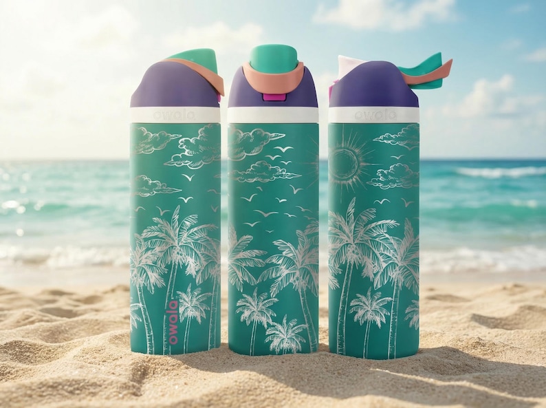 Three colorful water bottles with tropical palm tree designs are placed on a sandy beach, with the ocean visible in the background.