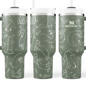A set of three green tumblers with a repeating pattern of dogs and bones printed on them.