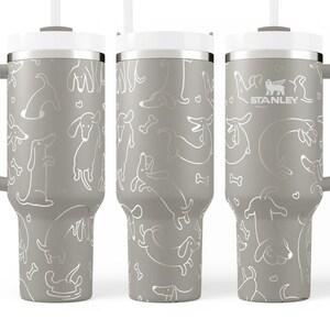 A set of three gray tumblers with a repeating pattern of dogs and bones printed on them.