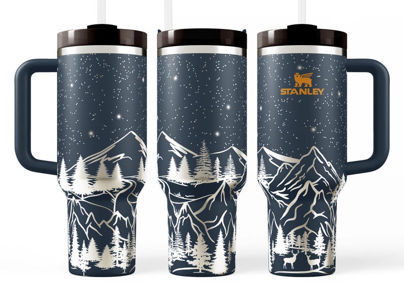 A set of three black insulated tumblers with a mountain landscape design printed on them.