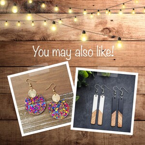 May include: Two pairs of earrings. The first pair features a gold circle with a colourful confetti design. The second pair features a long, rectangular wooden design with black and white paint.