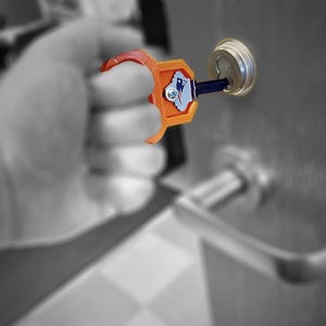 May include: An orange and red key tool is inserted into a silver door lock. The tool has a logo with a blue and white design. The background is in black and white.