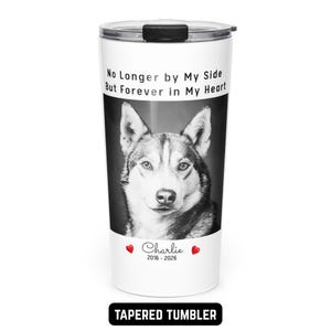 May include: White tapered tumbler featuring a black and white image of a husky dog. The tumbler has the text "No Longer by My Side But Forever in My Heart" and the name "Charlie" with the years 2016-2026. The bottom of the tumbler reads "TAPERED TUMBLER".