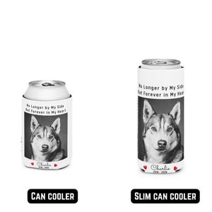 May include: Two white can coolers with a black and white image of a husky dog. The text on the can coolers reads "No Longer by My Side But Forever in My Heart" and "Charlie 2018-2024" and "Charlie 2016-2026". One is a can cooler and the other is a slim can cooler.