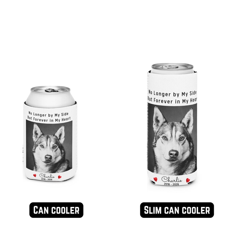 May include: Two white can coolers with a black and white image of a husky dog. The text on the can coolers reads "No Longer by My Side But Forever in My Heart" and "Charlie 2018-2024" and "Charlie 2016-2026". One is a can cooler and the other is a slim can cooler.