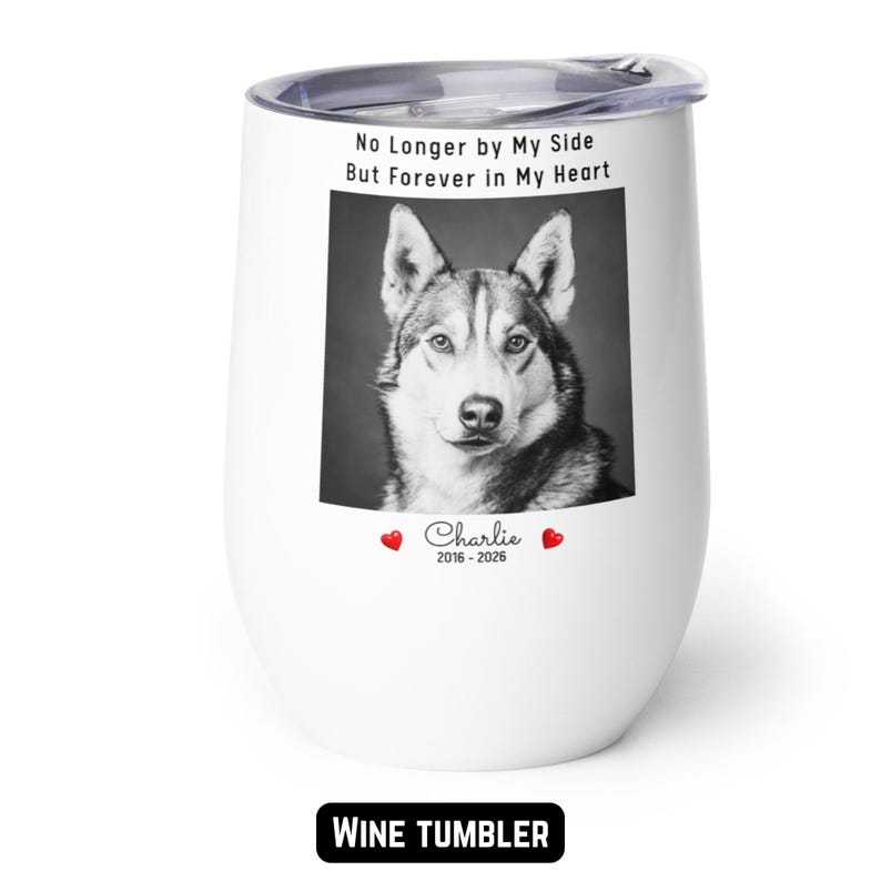 May include: White wine tumbler with a black and white image of a dog. The tumbler has the text "No Longer by My Side But Forever in My Heart" and the name "Charlie" with the years 2016-2026.
