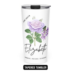 May include: White tapered tumbler with a lavender rose illustration, green leaves, and purple flowers. The name "Elizabeth" is written in cursive below the flower. Text includes "June Queen" and "Romantic, Patient, Extrovert." The bottom reads "Tapered Tumbler."