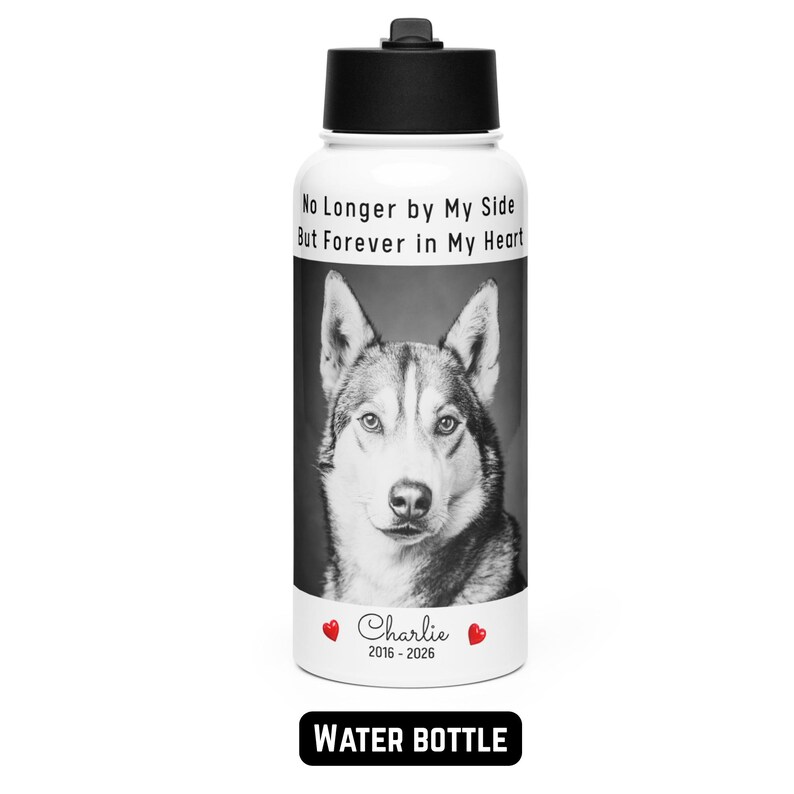 May include: A white water bottle with a black lid features a black and white portrait of a dog. The text "No Longer by My Side But Forever in My Heart" is above the dog's image. Below the image is the name "Charlie" and the years "2016-2026". The words "WATER BOTTLE" are at the bottom.
