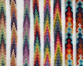 May include: Eight colorful friendship bracelets with different patterns and colors, including blue, green, red, yellow, orange, and purple. The bracelets are numbered 1 through 8.