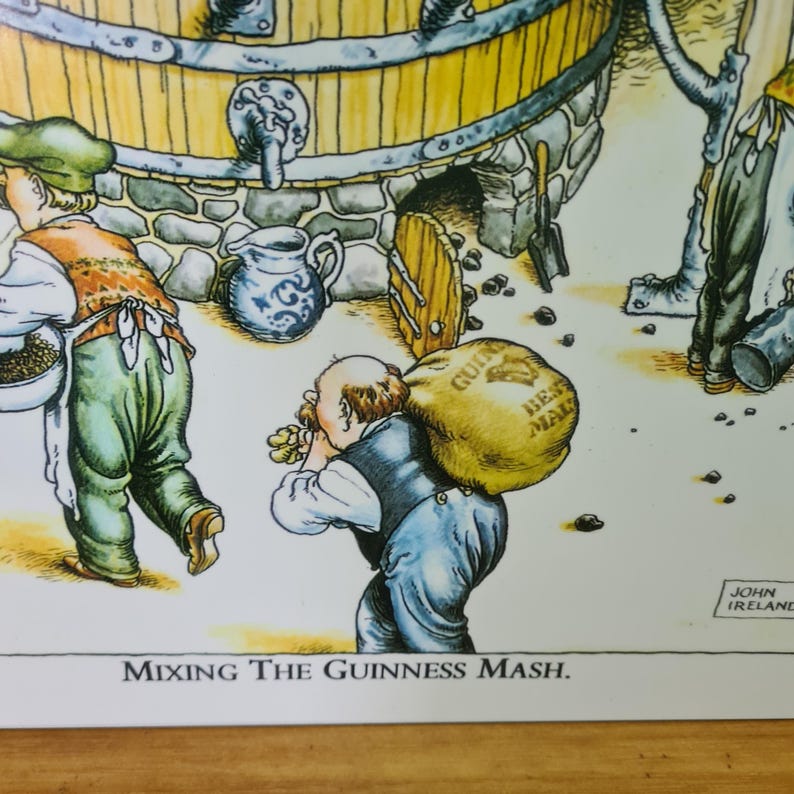 May include: A cartoon illustration of two men mixing Guinness mash. One man is holding a sack labeled "Guinness Best Malt" and the other is holding a scoop. The illustration is set against a background of a brick wall and a large wooden barrel.