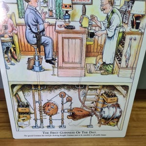 Puede incluir: Una ilustraci&oacute;n vintage que representa el proceso de servir la primera Guinness del d&iacute;a. La ilustraci&oacute;n muestra el interior de un pub con un barman sirviendo una pinta de Guinness, un cliente sentado en la barra y un gato sentado en el suelo. La parte inferior de la ilustraci&oacute;n muestra un sistema complejo de tuber&iacute;as y palancas que llevan la Guinness desde la bodega hasta la barra.