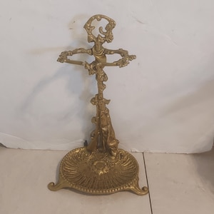 Soporte de latón ornamentado para bastón con detalle de cuerno de caza