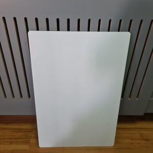 May include: A white rectangular cutting board with a smooth surface.