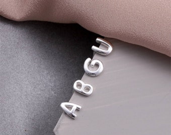 Puede incluir: Encantos de letras de plata en forma de las letras A, B, G y U.