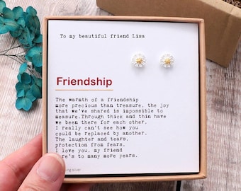 May include: A white card with a message about friendship, the words "To my beautiful friend Lisa" and "Friendship" are printed in black. The card is in a brown box with two small white daisy earrings with gold centers.