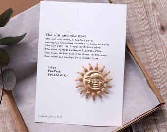 May include: A gold-colored sun and moon design with a poem about the sun and moon. The poem reads: "The sun and moon, a perfect pair, Beautiful opposites shining bright, so rare, The sun with its fiery, brilliant glow, The moon with its ethereal, gentle flow. One rises in the east, the other in the west, Two celestial beings in a cosmic duet. Love Perfect Friendship"