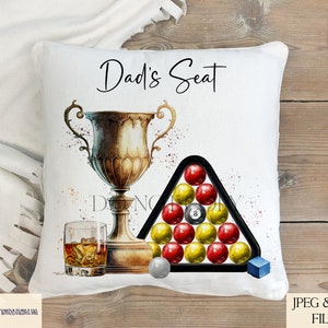 May include: White pillow with the text "Dad's Seat" printed in black. A gold trophy with a black and white pool ball rack with red and yellow pool balls is in the center of the pillow.