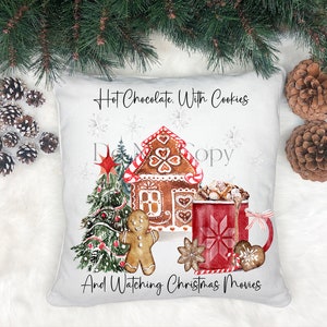 May include: A white throw pillow with a Christmas-themed design. The pillow features a gingerbread house, a Christmas tree, a gingerbread man, a mug of hot chocolate with marshmallows, and the text "Hot Chocolate. With Cookies And Watching Christmas Movies".