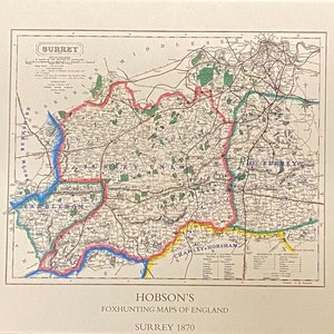 May include: An antique map of Surrey, England, from 1870. The map is printed in black, red, blue, green, and yellow ink on cream-colored paper. The map shows the county boundaries, rivers, roads, and towns. The title "Hobson's Foxhunting Maps of England Surrey 1870" is printed at the bottom of the map.