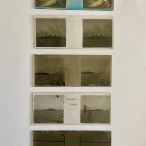 May include: A series of vintage photographic slides showing naval vessels at sea. The slides are predominantly sepia-toned, with some featuring handwritten annotations. The top slide is in colour and includes the text "H.M.B. Invincible at Coronation Review."