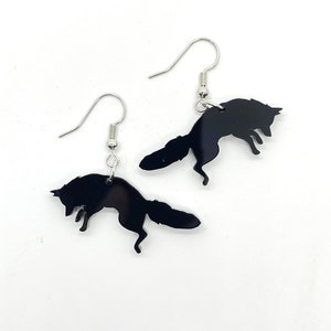 May include: A pair of black fox silhouette earrings with silver hooks. The foxes are jumping in mid-air.