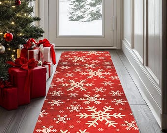 Op de afbeelding: Een rode loper met een sneeuwvlokkenpatroon. Het tapijt heeft een herhalend ontwerp van witte sneeuwvlokken op een rode achtergrond. Het is geplaatst voor een deur, met een kerstboom en ingepakte cadeaus op de achtergrond.