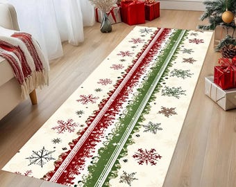 Op de afbeelding: Een rechthoekig kersttapijt met een crèmekleurige achtergrond. Het tapijt heeft een centraal ontwerp van rode en groene strepen met sneeuwvlokpatronen. Het tapijt ligt op een houten vloer.