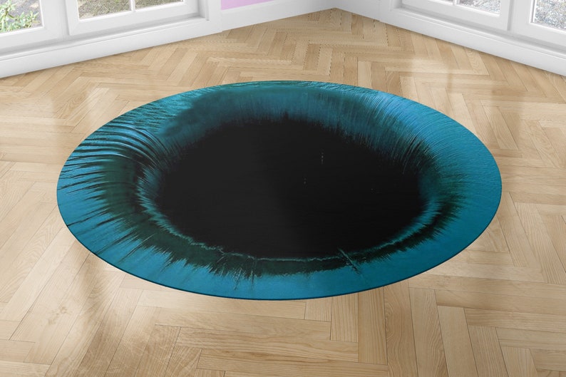 May include: A round, teal blue and black rug with a swirling pattern. The center of the rug is a black circle.