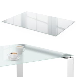 Peut inclure: Table rectangulaire en verre avec une surface réfléchissante. La table a un design moderne avec un plateau en verre transparent et un pied en métal argenté. Deux tasses à café blanches sont posées sur la table.