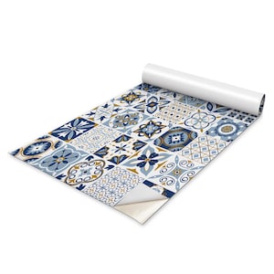 May include: A roll of patterned vinyl flooring with a repeating tile design. The tiles feature a mix of blue, white, and gold floral and geometric patterns. The roll is partially unrolled, revealing the design.