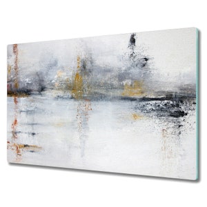 Puede incluir: Impresión artística abstracta con un diseño inspirado en el paisaje. La obra de arte utiliza una paleta de blanco, gris, negro y dorado. Las pinceladas verticales y horizontales crean un efecto texturizado. La impresión está montada sobre un panel de vidrio rectangular.