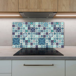 May include: A blue and white patterned tile backsplash for a kitchen or bathroom. The backsplash is made up of many small tiles with different designs. The backsplash is installed above a black hob.