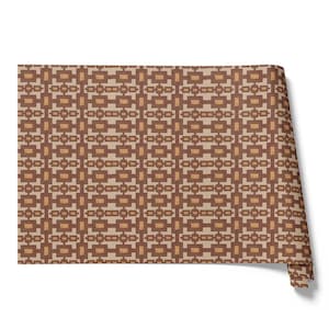 Peut inclure: Un rouleau de tissu à motifs avec un design géométrique dans les tons de marron et beige. Le motif répété présente des formes rectangulaires et carrées, créant une esthétique rétro. Le tissu est partiellement enroulé, révélant le motif.