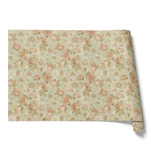 Pode incluir: Um rolo de papel de parede floral com um padrão repetido de rosas cor-de-rosa e creme e folhas verdes sobre um fundo verde pálido. O papel de parede tem uma estética vintage e romântica.