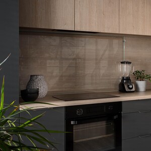 Könnte beinhalten: Eine moderne Küche mit schwarzen Schränken und einer Holzmaserung an der Rückwand. Die Arbeitsplatte ist aus Holz und hat ein schwarzes Elektrokochfeld und einen schwarzen Backofen. Auf der Arbeitsplatte stehen ein Mixer und eine Vase mit Trockenblumen.