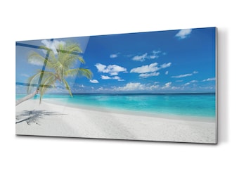 May include: A panoramic view of a tropical beach with a single palm tree leaning towards the turquoise water. The white sand beach stretches out to the horizon under a bright blue sky with fluffy white clouds.
