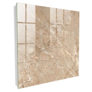 May include: A square wall panel featuring a glossy, polished finish with a beige and tan marble pattern. The surface displays intricate white veining throughout the stone-like design, creating a reflective appearance with a smooth, flat texture.