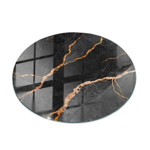 Pode incluir: Uma superfície redonda preta com padrão de mármore e veios dourados. A superfície tem um acabamento brilhante e reflete a luz. O design apresenta um fundo escuro com linhas douradas contrastantes. Diâmetro de aproximadamente 30 cm.