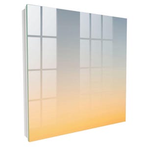 Può includere: Un pannello artistico da parete quadrato in vetro caratterizzato da una sfumatura di colore uniforme che passa da un azzurro tenue in alto a un caldo arancione dorato in basso, con una superficie riflettente che mostra un leggero riflesso di finestra.