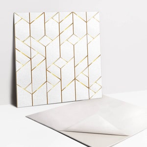 Könnte beinhalten: Eine weiße Karte mit einem geometrischen Muster aus goldenen Linien. Die Karte ist in der Mitte gefaltet und die Vorderseite ist sichtbar. Die Karte liegt auf einer weißen Oberfläche.
