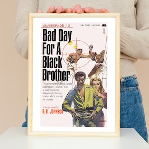 Puede incluir: Una portada de libro de bolsillo vintage con una ilustración en blanco y negro de un hombre en un ring de boxeo. El título del libro es "Bad Day For A Black Brother" de B.B. Johnson. La portada está en un marco.