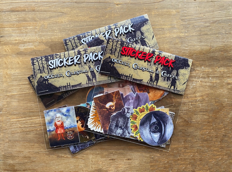 May include: A clear plastic bag filled with a variety of stickers. The stickers feature illustrations of occult, celestial, and creepy themes. The bag is labeled with the text "Sticker Pack Occult, Celestial & Creepy".