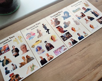 May include: Four sheets of stickers featuring characters from the TV show "The Good Place". Each sheet has the title "Season Two Sticker Sheet" printed in a retro font. The stickers feature various characters from the show, including Eleanor, Chidi, Tahani, Jason, Michael, and Janet.