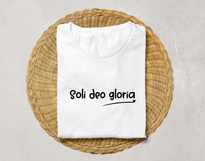 May include: White t-shirt with the text "Soli Deo Gloria" printed in black.